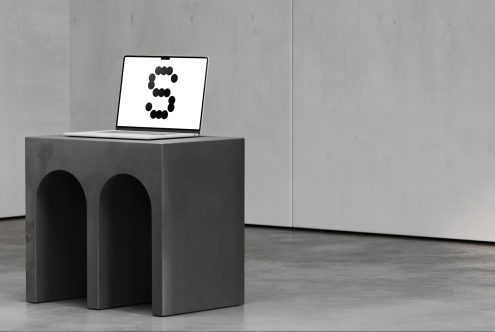 Minimalist mockup featuring a laptop on a modern concrete table. Ideal for design projects showcasing digital fonts and sleek workspace setups.