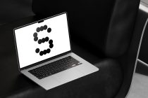 Laptop displaying number 3 made from black dots on dark leather background