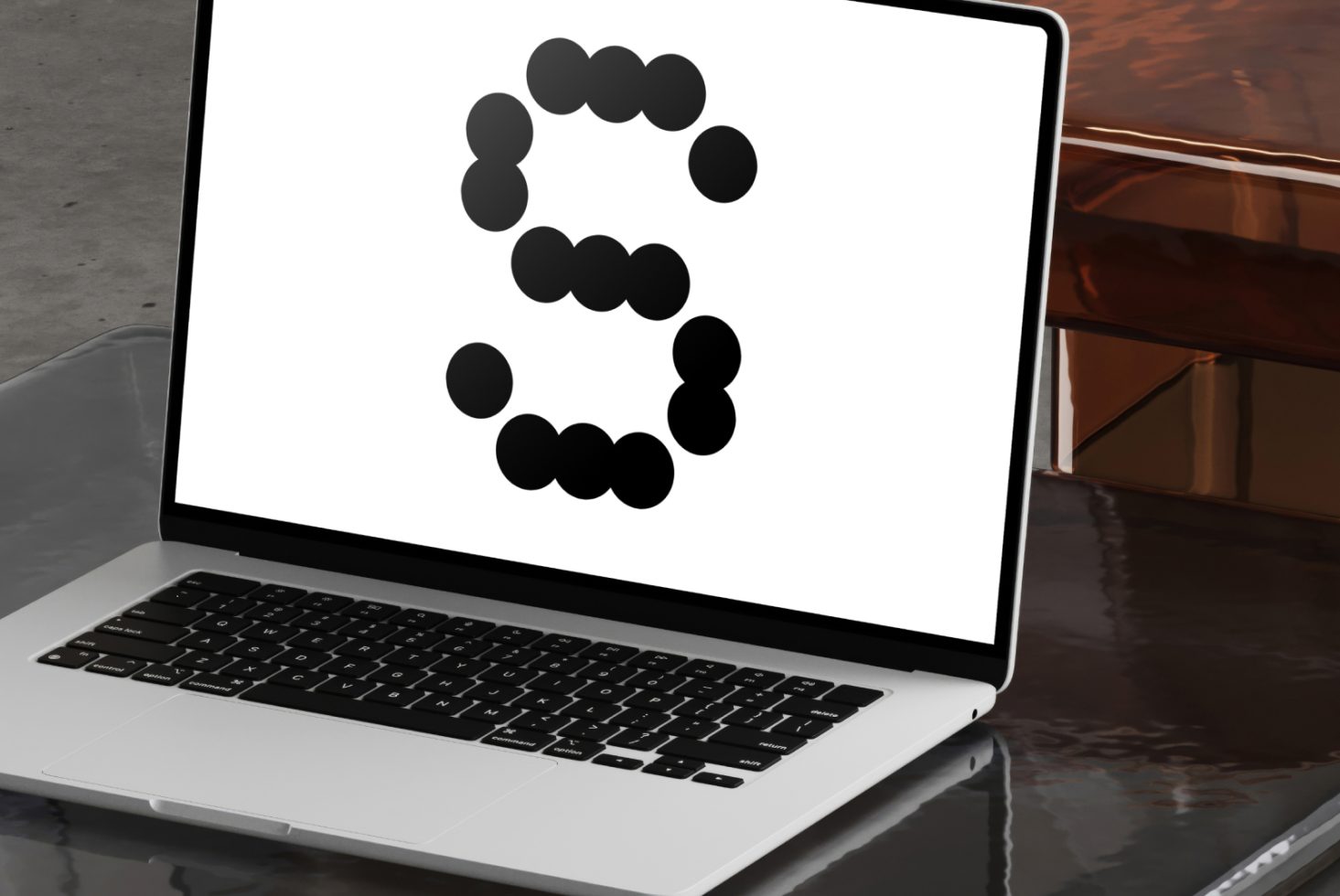 Laptop displaying a modern graphic of the letter S composed of black dots on a white screen perfect for designers looking for unique typography or fonts.