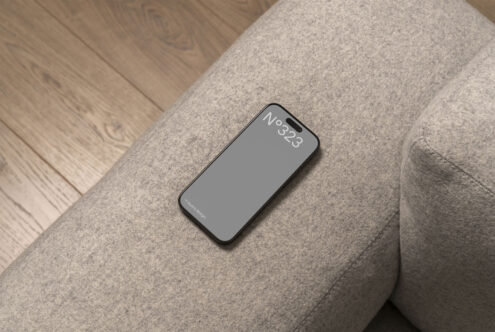 Smartphone mockup on a gray fabric sofa with wooden floor background perfect for UI UX design. Ideal for showcasing mobile apps or responsive websites.