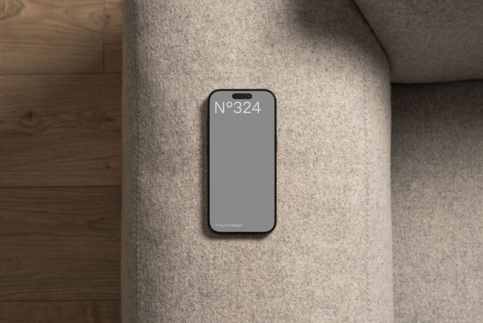 Smartphone mockup on a gray fabric couch flat lay. Ideal for showcasing mobile app designs or responsive templates. Keywords: mockups design digital.