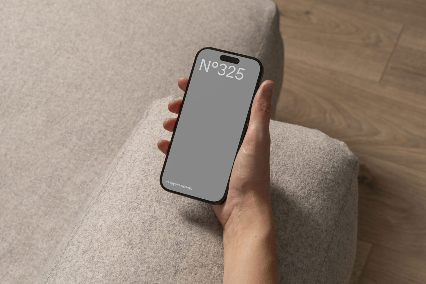 Hand holding smartphone with blank screen for mockup design. Cozy interior setting with soft texture. Ideal for designers and digital assets. Templates.