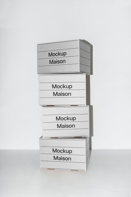 Stack of four minimalist grey boxes mockup labelled Mockup Maison on a white background. Perfect for packaging presentations, branding mockups, and design projects.