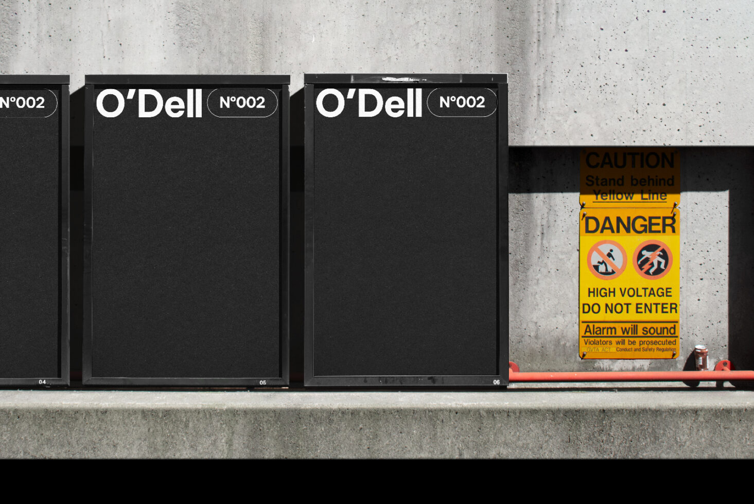 Black speaker boxes labeled O'Dell N002 on a concrete background with a caution sign nearby. Ideal for mockups and design templates. High voltage warning.