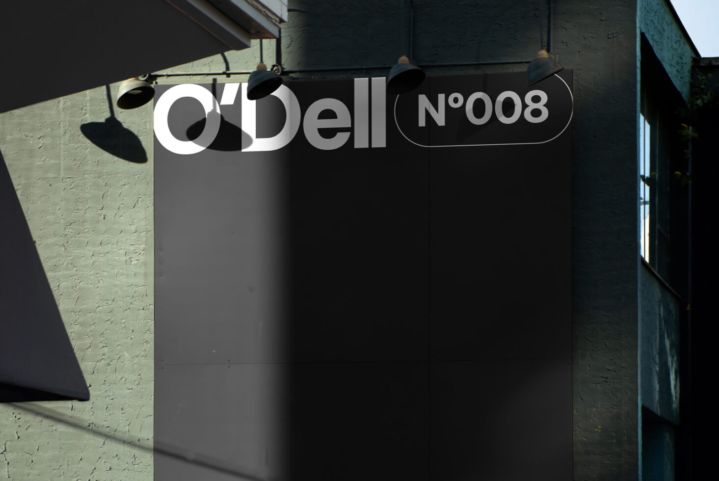 Mockup of a large outdoor sign on a textured building wall with modern sans-serif typography reading O'Dell No008 ideal for branding and advertising designs.