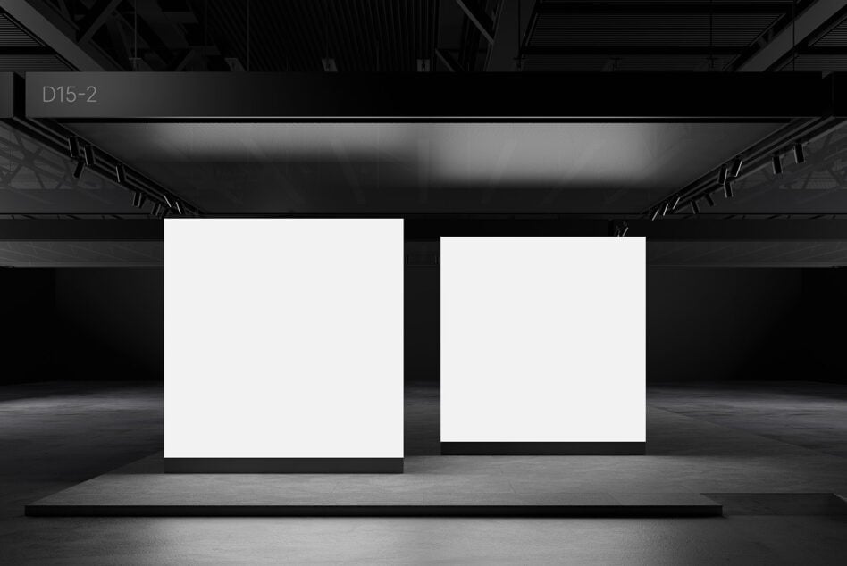 Two blank white square panels standing in dark industrial gallery setting