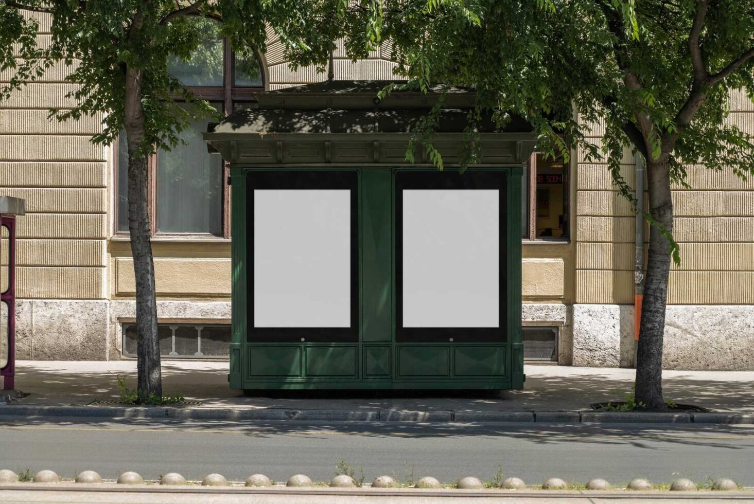 Outdoor advertising mockup on green kiosk in urban setting. Blank posters framed by trees. Perfect for graphic design templates and billboard presentations.