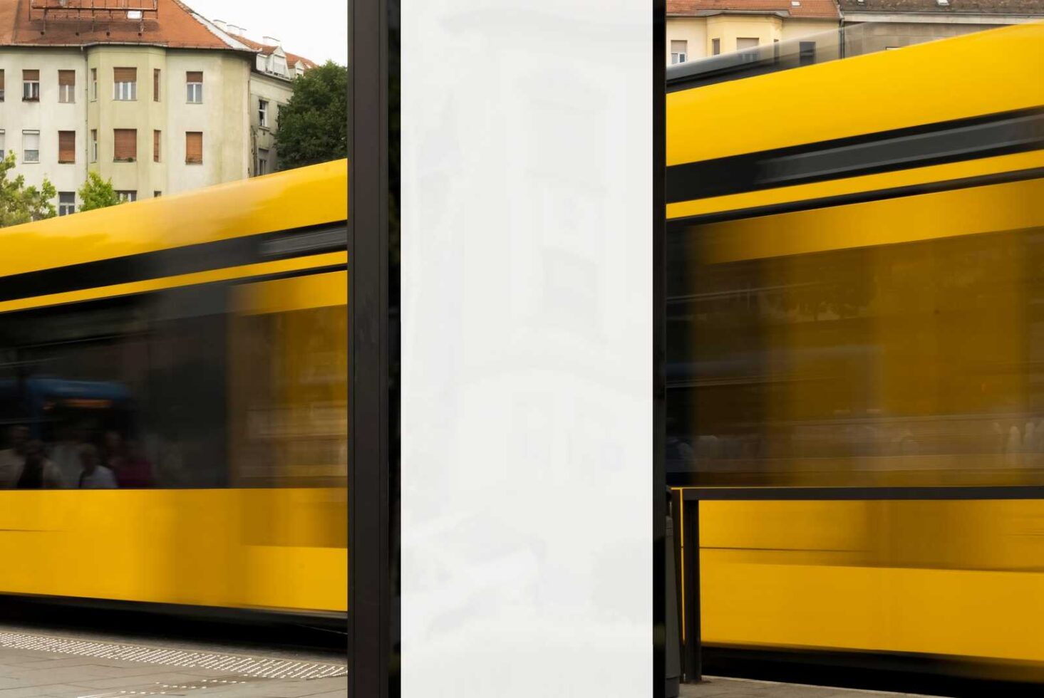 Blank billboard mockup next to a moving yellow tram in an urban setting ideal for advertising designs. Perfect for mockup and template designers.