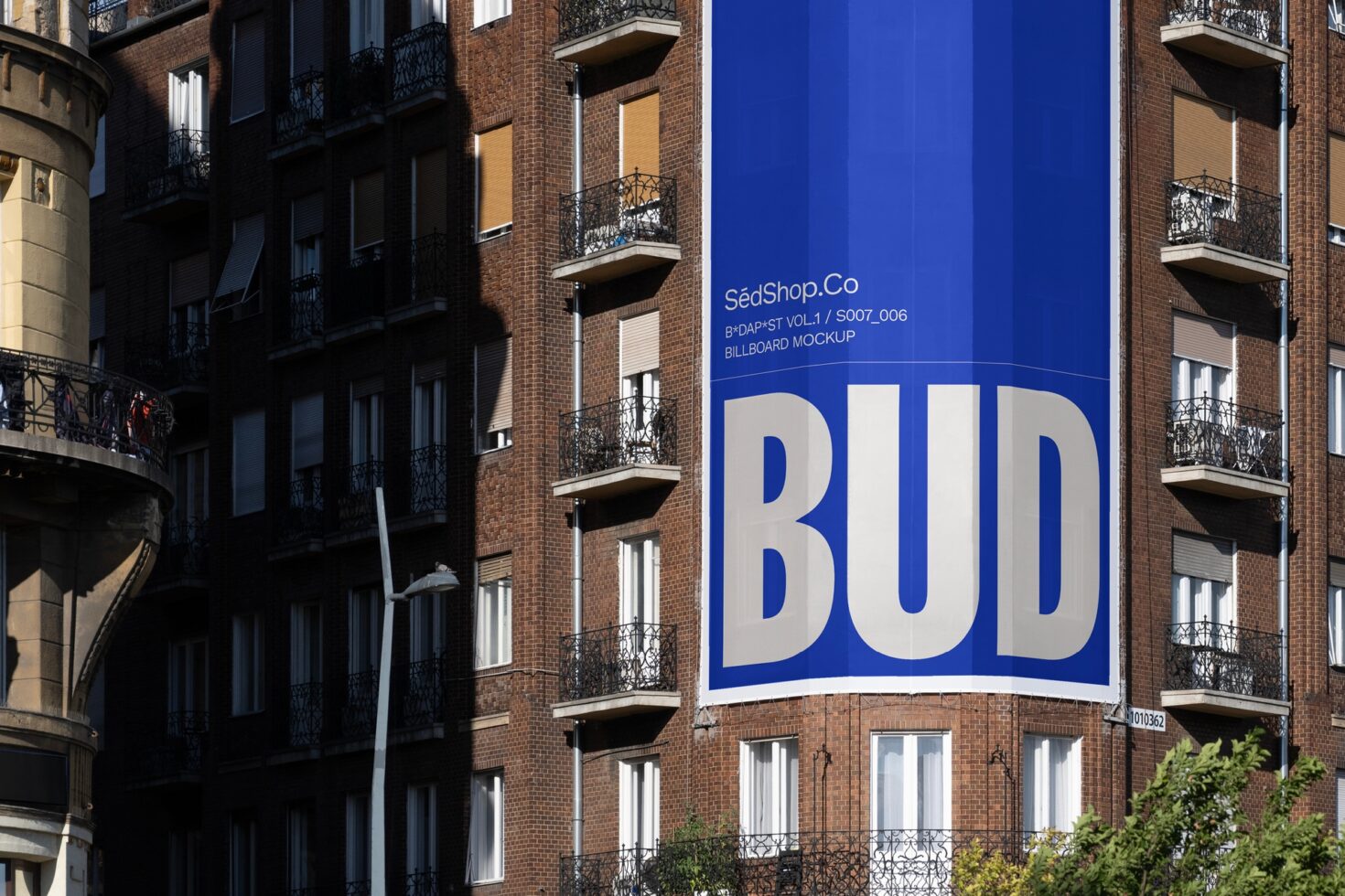 Urban building billboard mockup in bright blue with bold text BUD perfect for advertising designers seeking realistic street graphics display resources