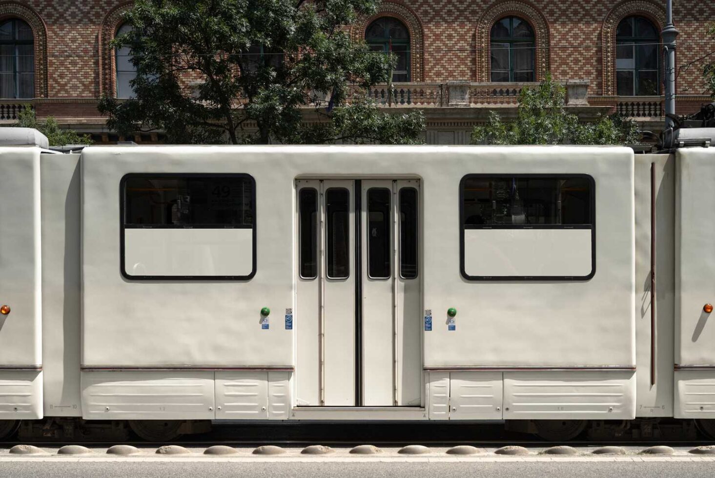 Side view of a tram with closed doors and urban background suitable for mockups and graphic design. Keywords include tram design urban transportation.