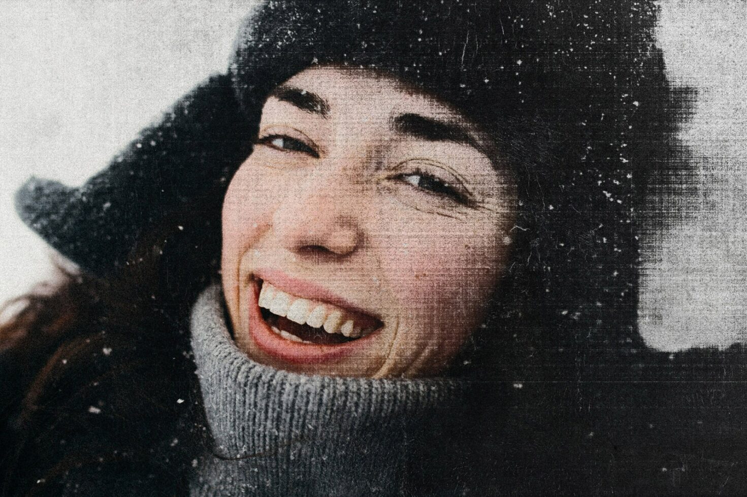 Close-up of a smiling woman in a winter hat with a vintage textured effect, ideal for winter-themed mockups and graphic design projects.