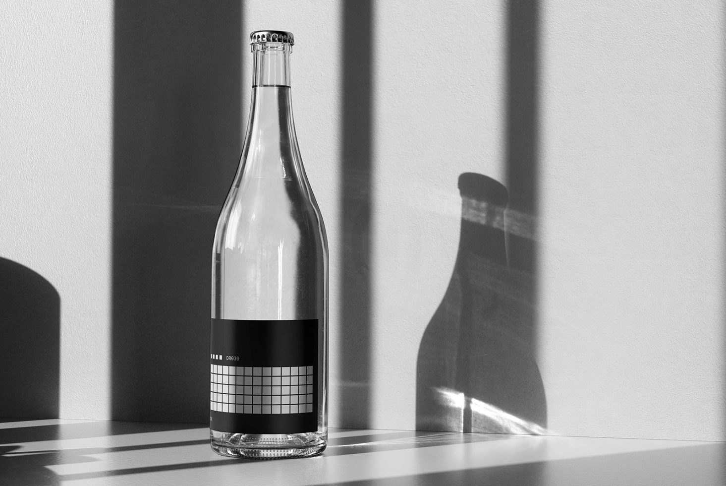 Black and white wine bottle mockup with geometric label shadow on wall minimalist design template for product branding packaging and graphic design.