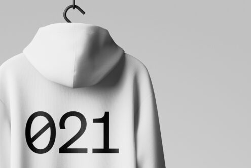 Mockup of a white hoodie hanging on a hook, featuring bold black numbers on the back. Perfect for designers seeking customizable apparel graphics.