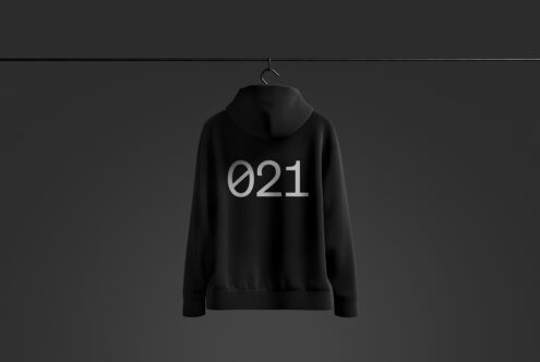 Black hoodie mockup on dark background featuring minimalist 021 text design; ideal for apparel design presentations and fashion branding templates.