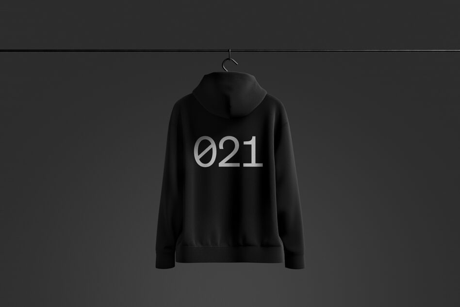 Black hoodie mockup on dark background featuring minimalist 021 text design; ideal for apparel design presentations and fashion branding templates.