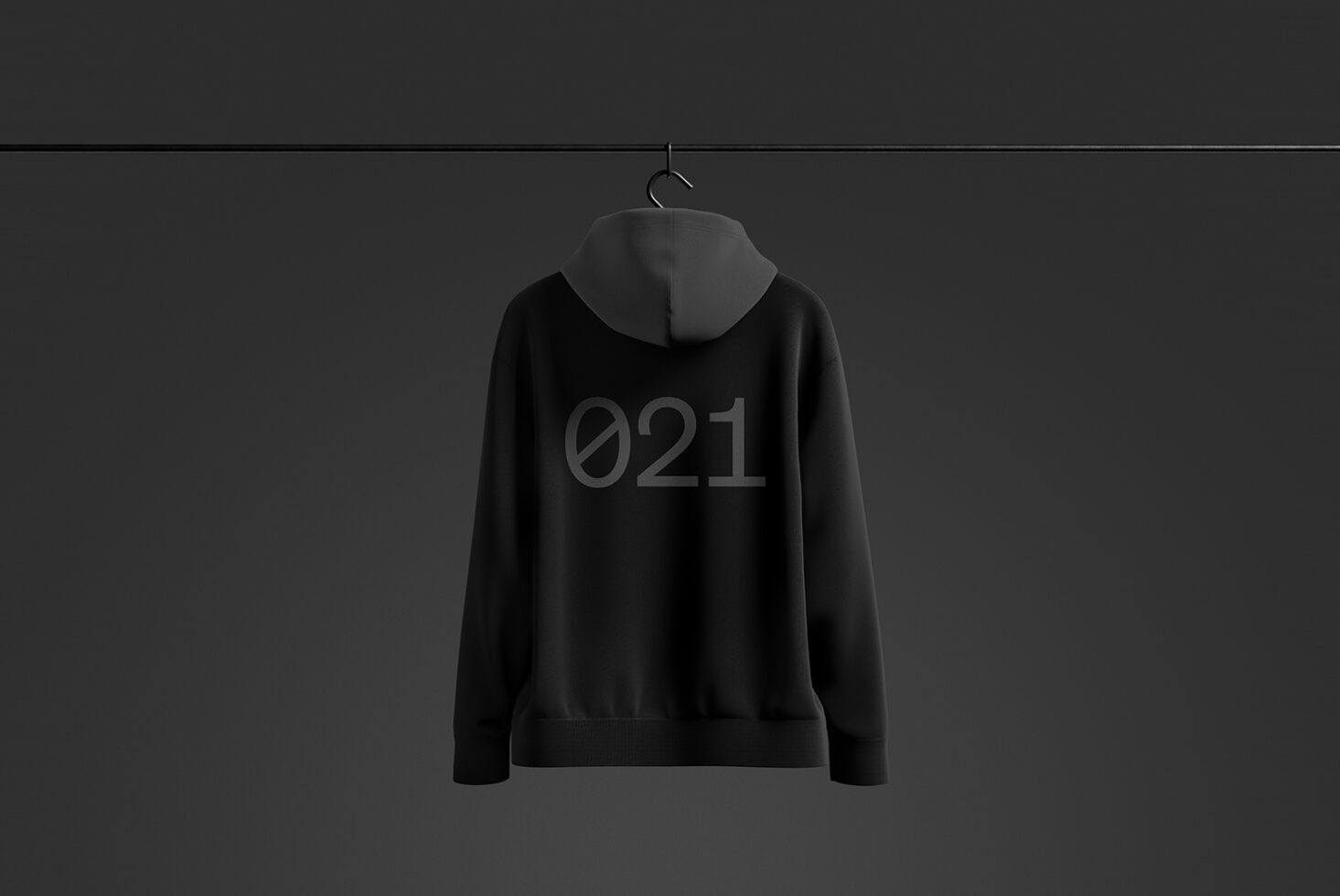 Mockup of a black hoodie with the number 021 on the back hanging on a black hanger against a dark background. Ideal for fashion design and branding.