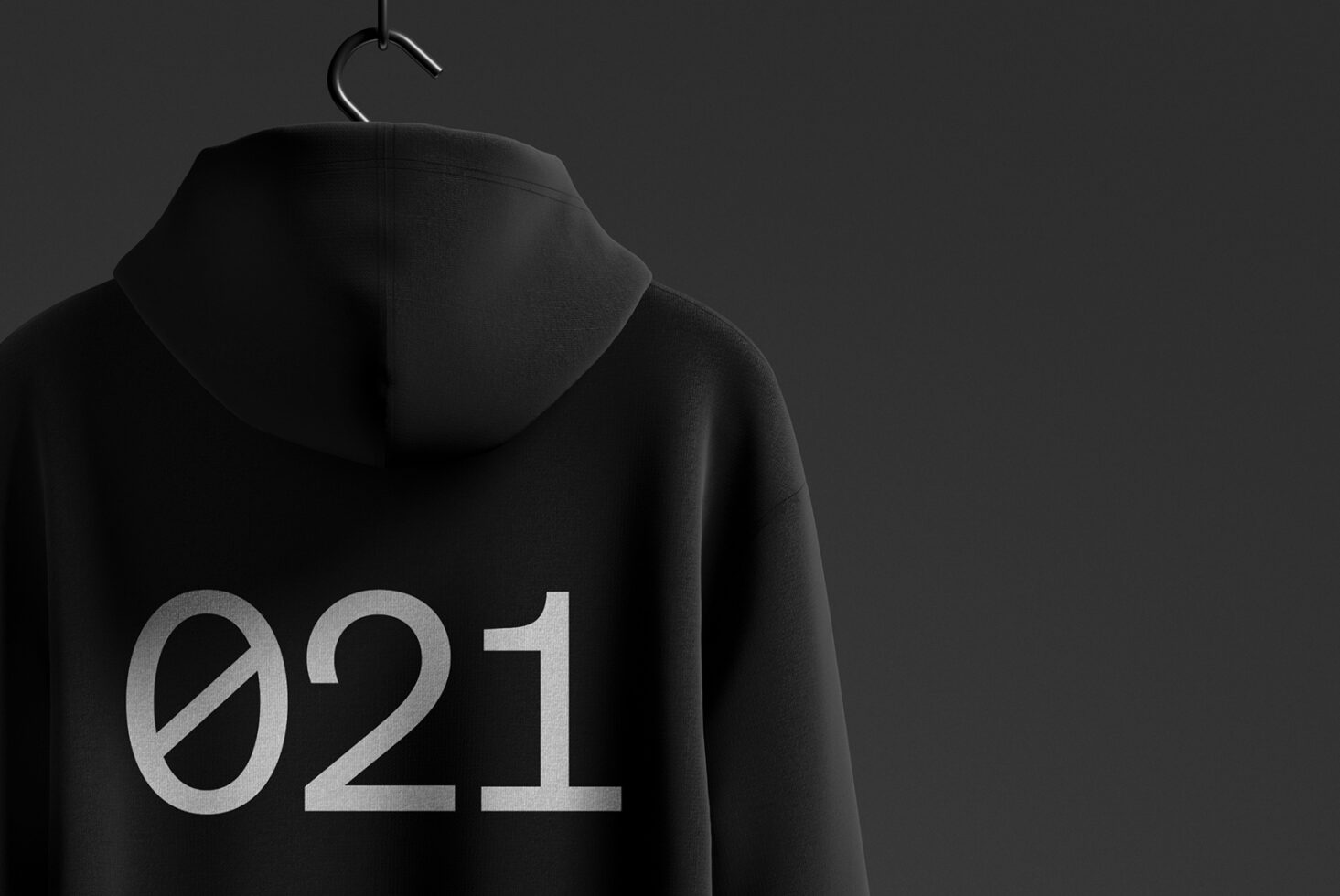 Black hoodie hanging on a hanger with 021 printed in bold white text on the back. Apparel mockup suitable for designers. Fashion design template.