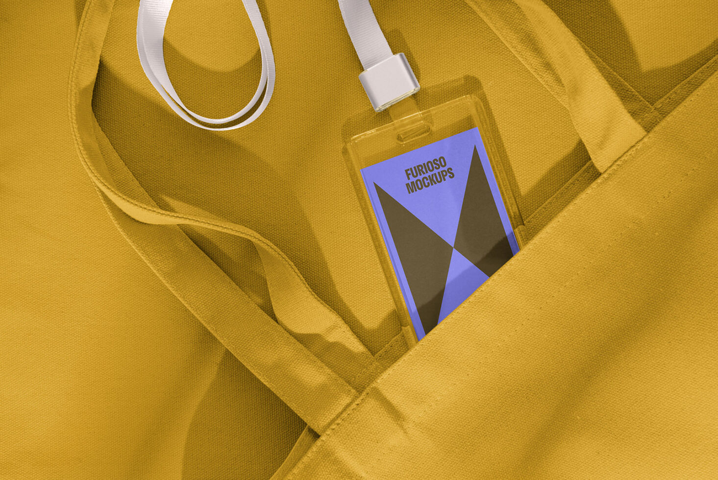 Designer mockup of a lanyard badge with geometric design inside a yellow canvas bag. Ideal for showcasing branding and event designs. Keywords: mockup, design, branding.