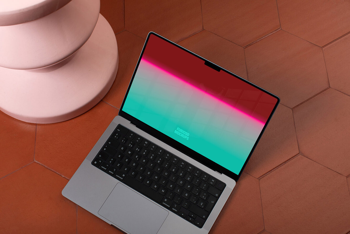 Laptop mockup with colorful gradient screen on terracotta hexagonal tiles beside a round pink pedestal ideal for graphic design presentations.