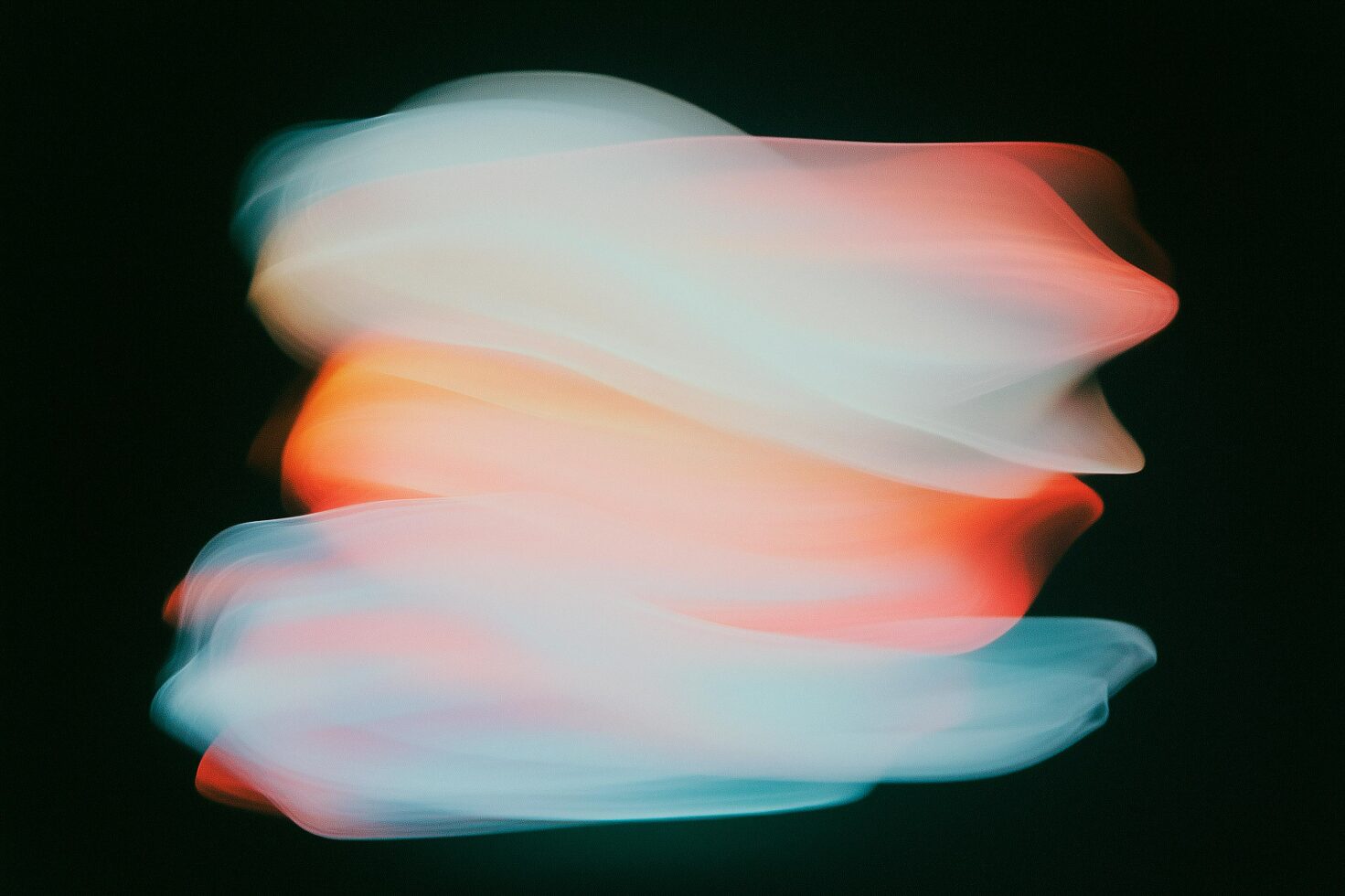 Abstract light streaks in motion create a dynamic gradient effect with warm orange and cool blue tones on dark background. Perfect for graphic design templates.