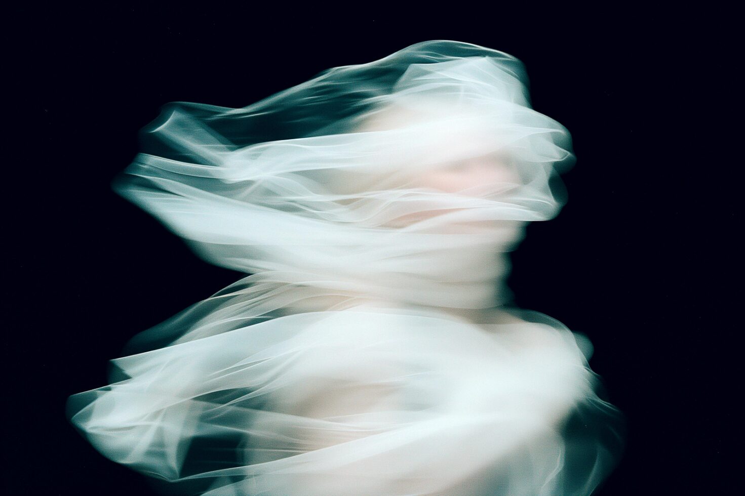 Abstract motion blur photography featuring ethereal swirling white fabric on dark background perfect for designers exploring minimalist graphic assets.