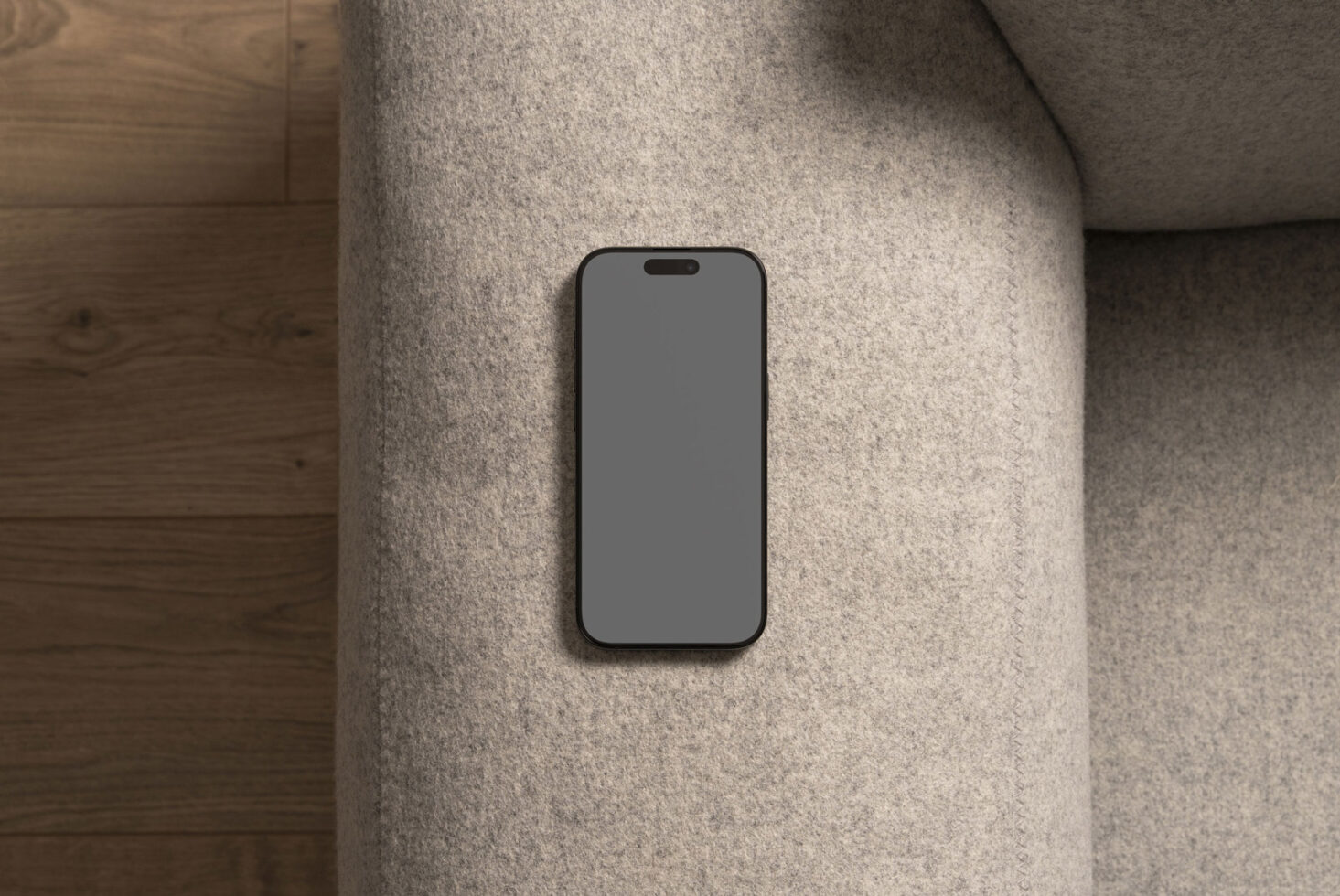 Phone mockup on a gray sofa showcasing a blank screen ideal for app design display or template use. Modern minimal smartphone mockup for designers.