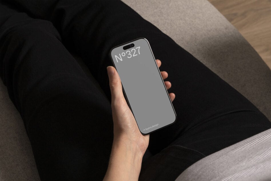 Hand holding iPhone with light screen displaying N°327 on black fabric