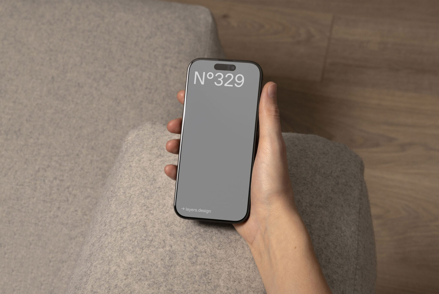 A designer holds a smartphone displaying a minimalist mockup on a gray background. Ideal for product design presentations and digital assets.