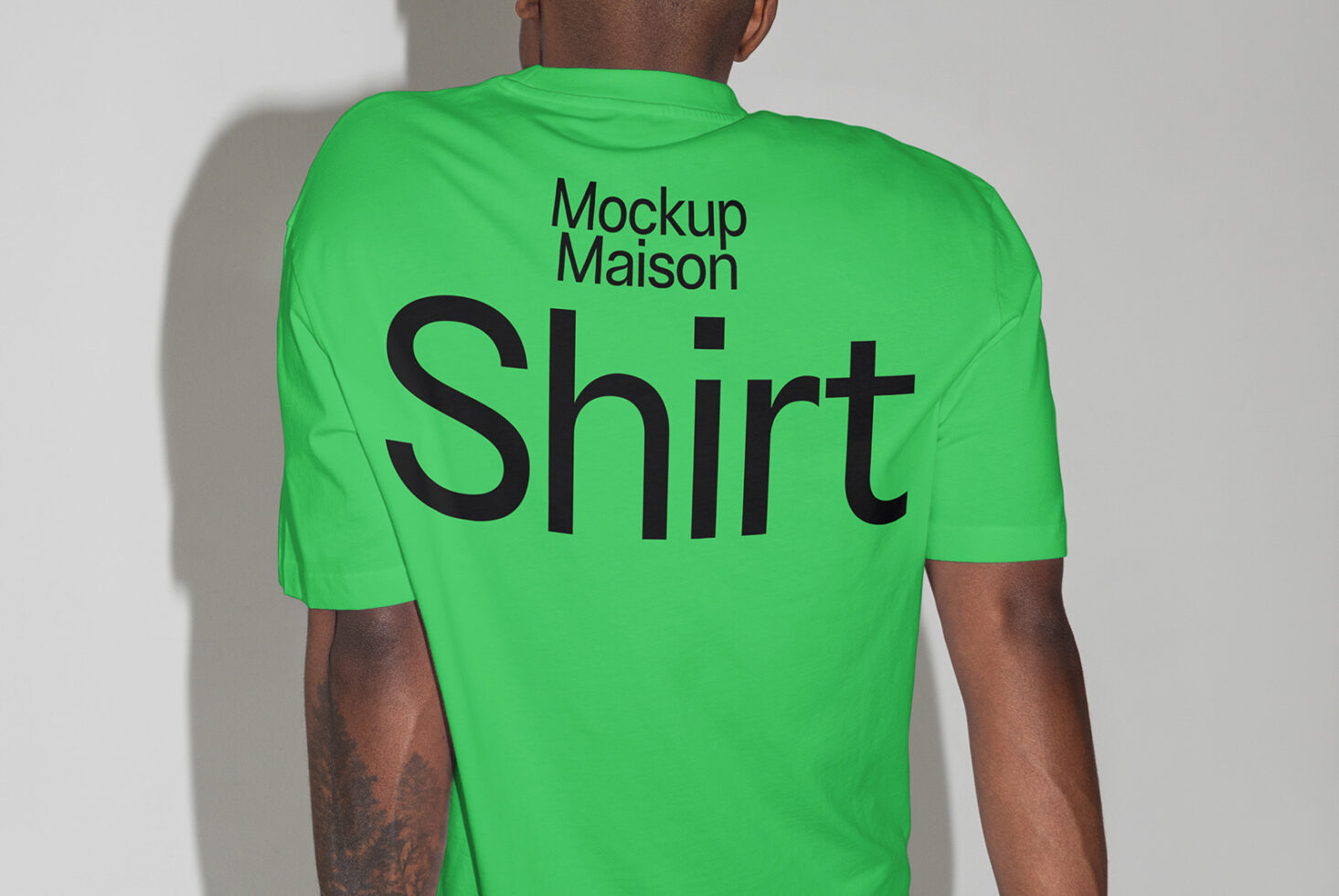 Green t-shirt mockup featuring bold black text from Mockup Maison. Ideal for designers seeking customizable apparel templates for branding or presentations.