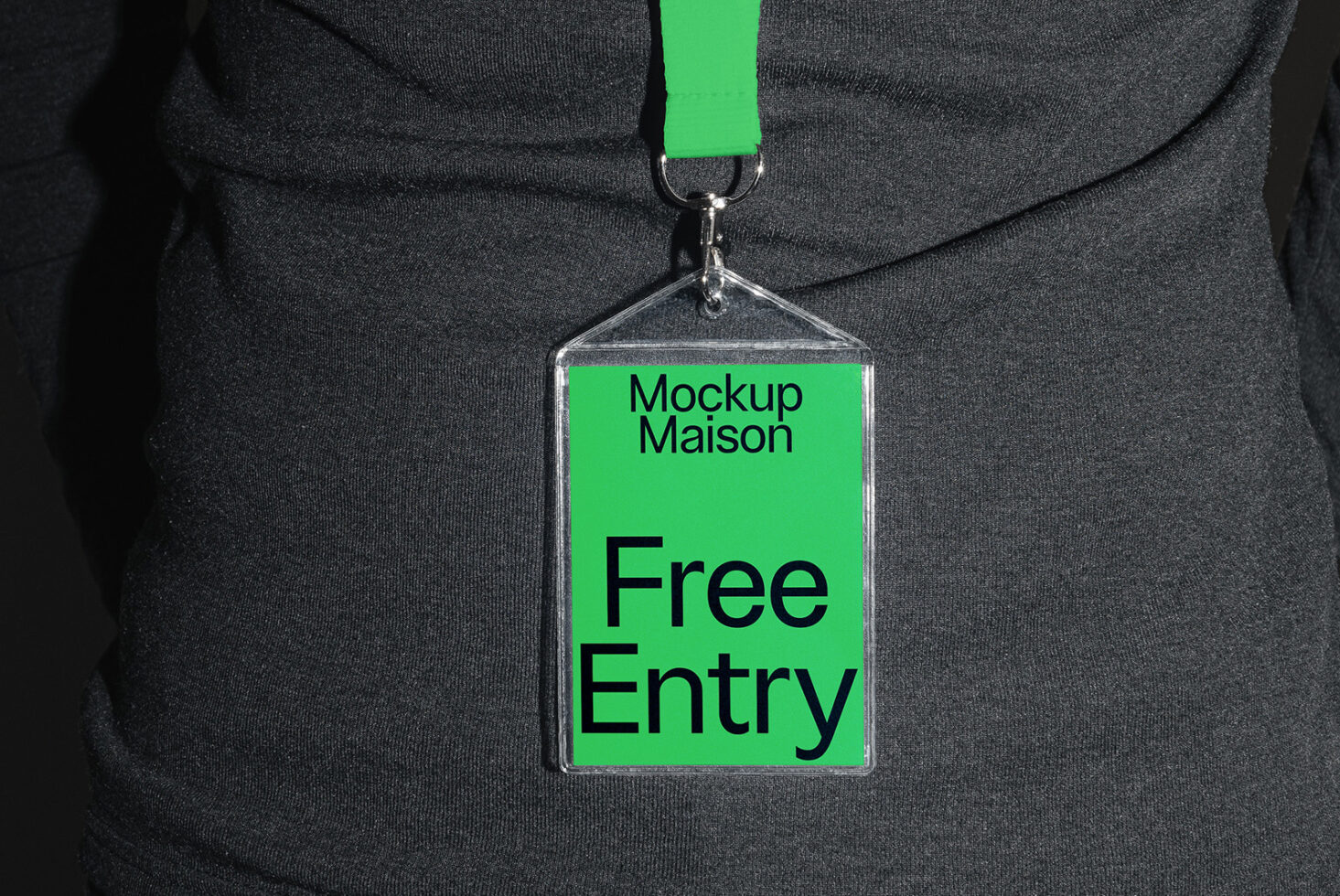 ID card mockup with green tag labeled Free Entry against a dark shirt. Ideal for showcasing event access designs. Keywords: mockup, ID, badge design.