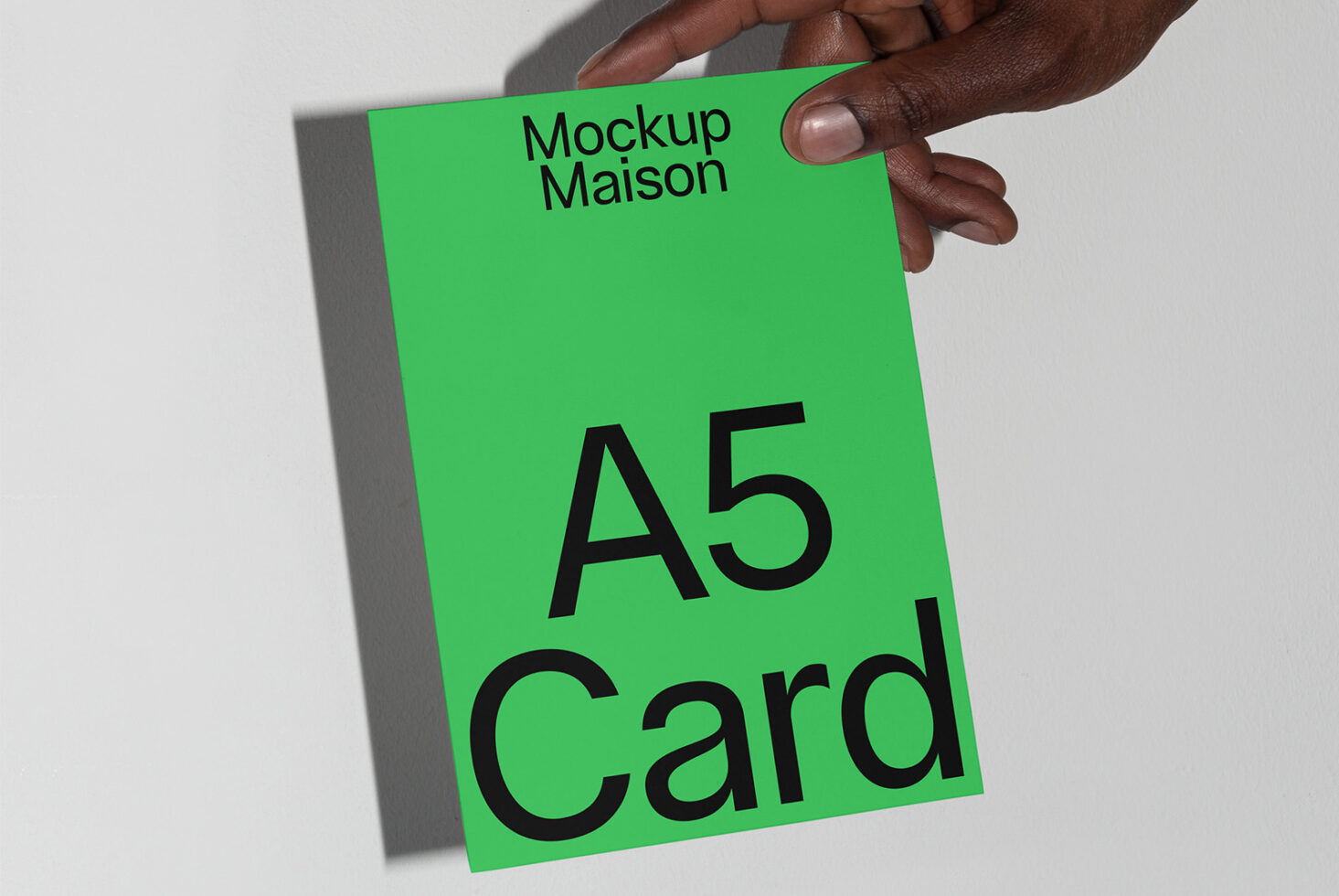 Hand holding A5 card mockup with green background suitable for designers showcasing templates marketing materials and print design presentations.