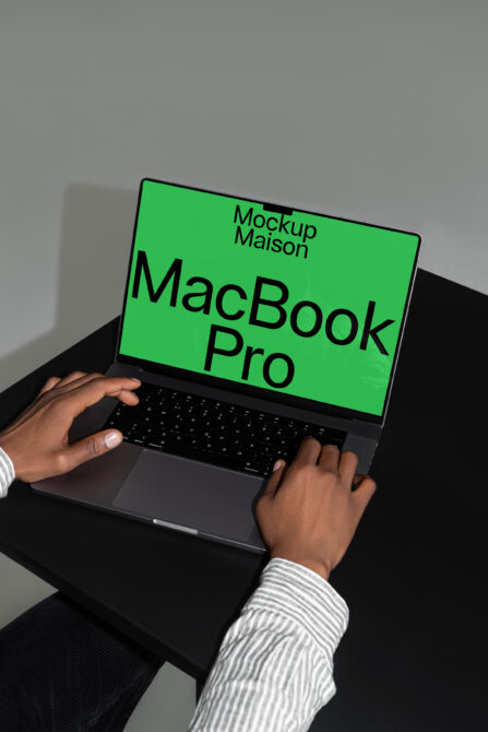 MacBook Pro mockup with green screen and user typing. Ideal for digital designers creating templates. Keywords: mockups, design resources, laptop.