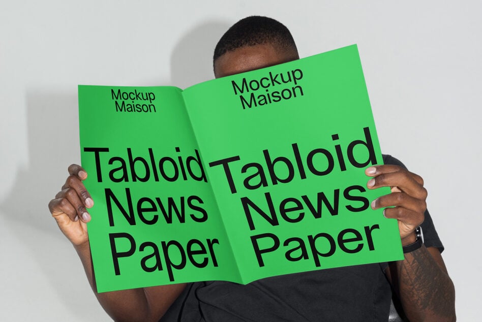 Person holding open lime green magazine mockup with Tabloid News Paper text visible