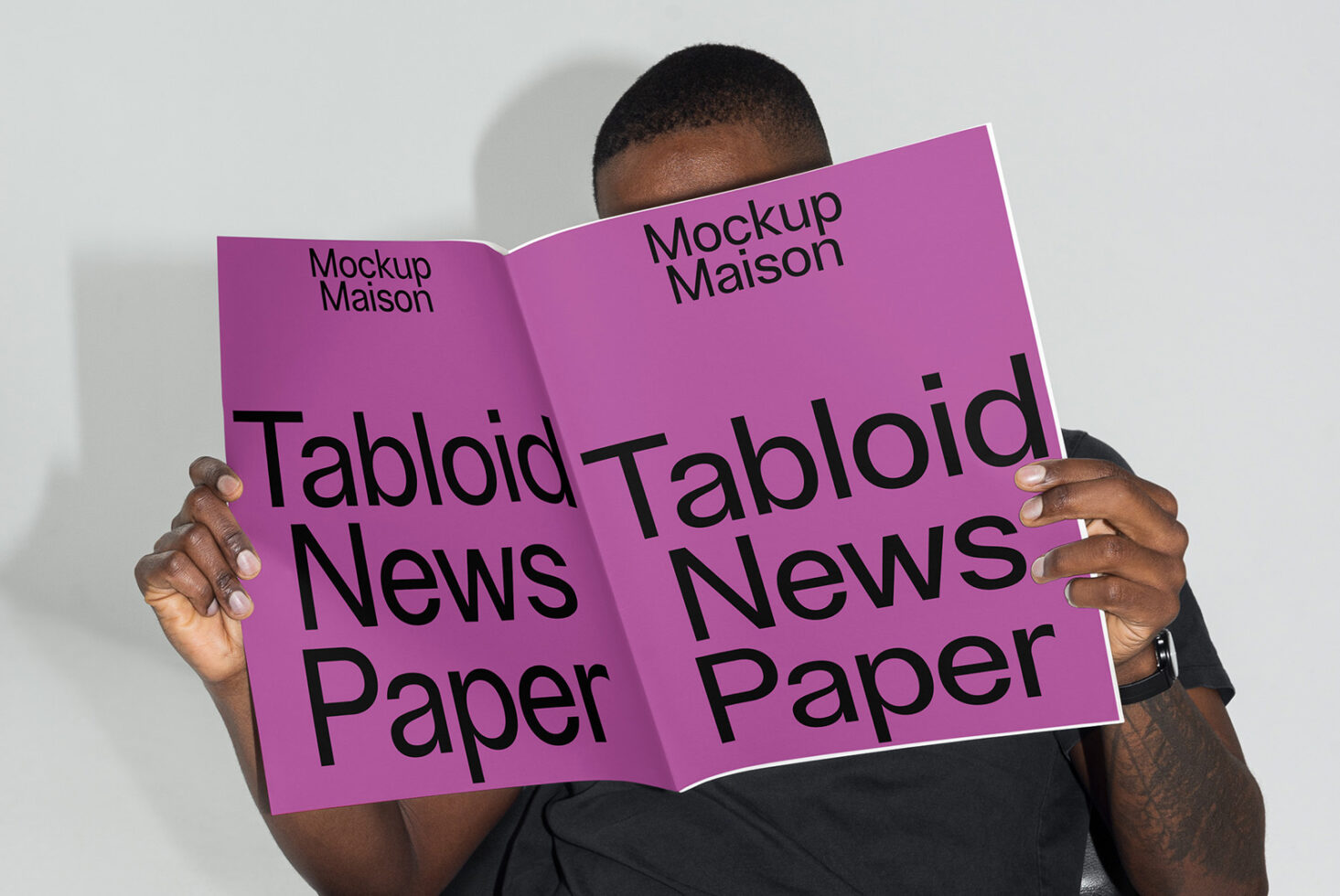 Designer holding a customizable tabloid newspaper mockup with a purple cover ideal for showcasing graphic designs and templates for creative projects.