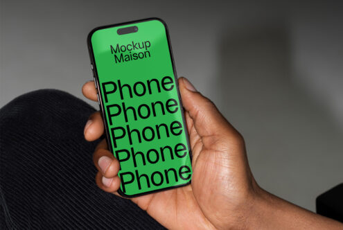 Phone mockup template in a hand showcasing design potential with bold text on a green background. Ideal for graphic designers seeking modern presentation.