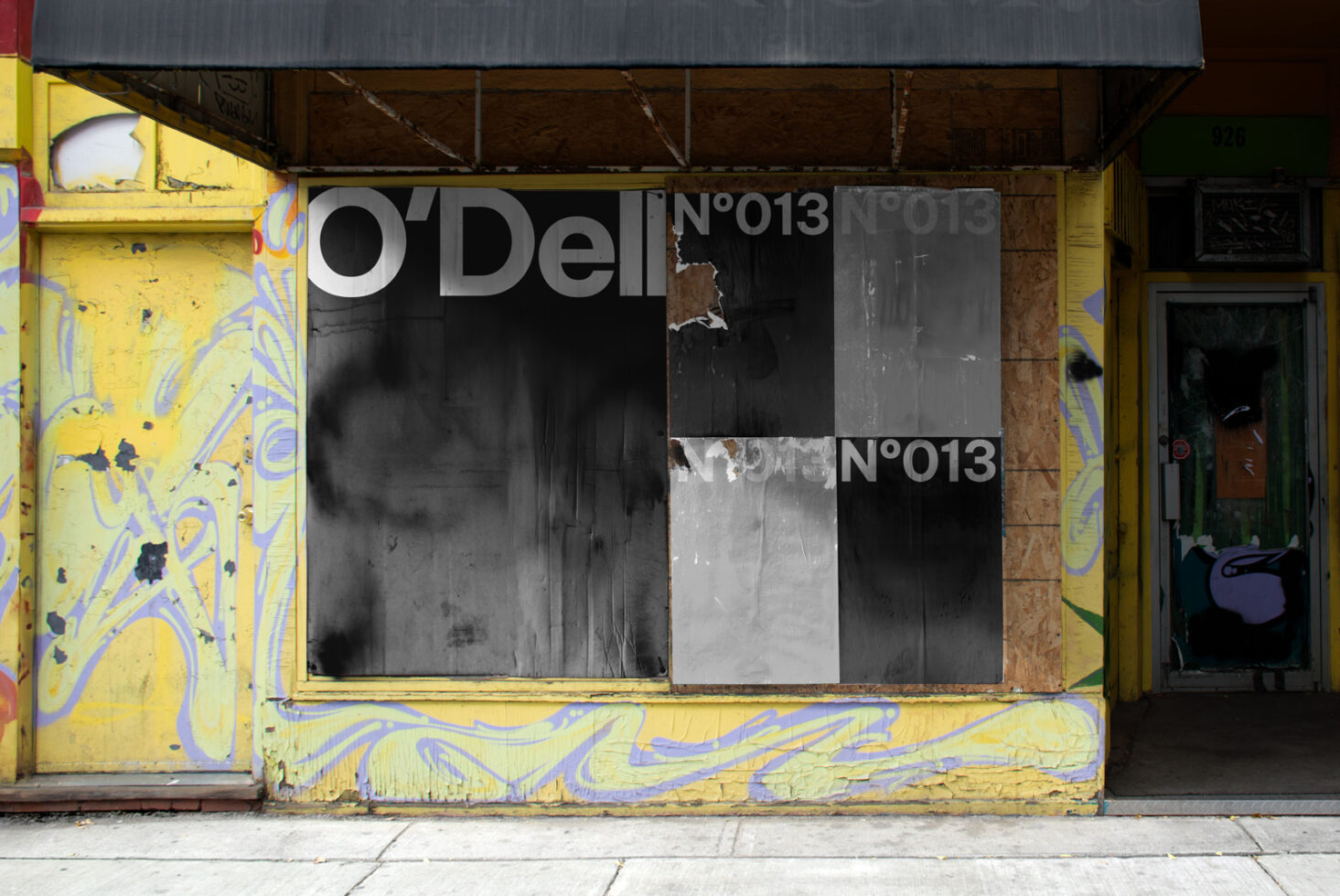 Urban storefront mockup with textured posters on weathered wall. Ideal for showcasing graphics or street art designs. Graffiti adds artistic flair.