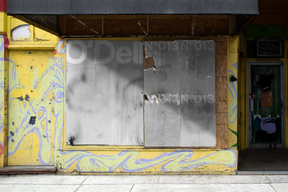 Urban storefront with colorful graffiti art and metal panels. Grunge aesthetic, perfect for designers seeking gritty textures and urban design inspiration.