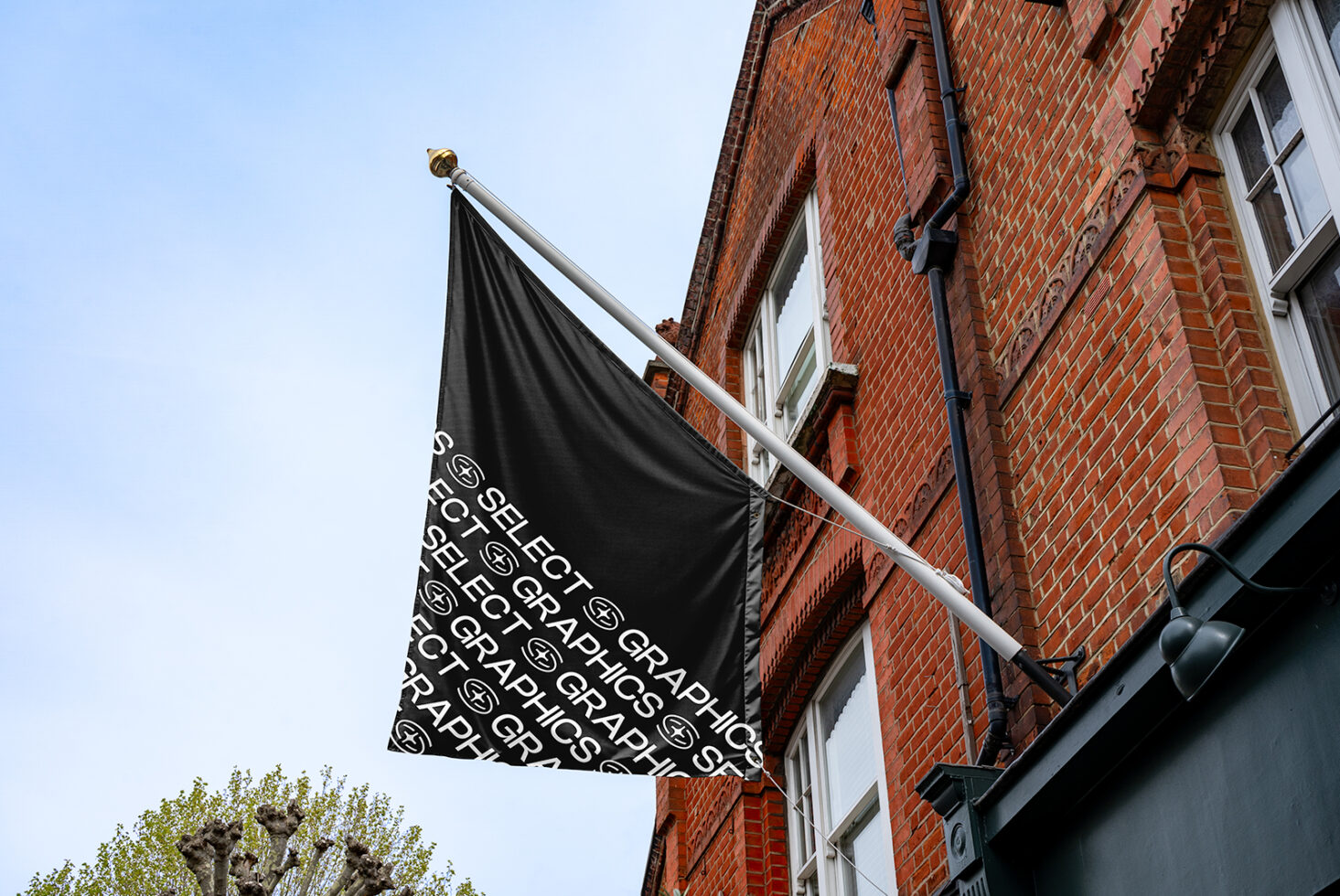 Black flag on brick building facade featuring repeating text Select Graphics suitable for mockup template showcasing design or logo branding in urban setting.