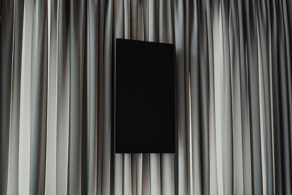 Black vertical frame mockup on elegant beige curtains background ideal for designers showcasing digital artwork mockup template interior design.