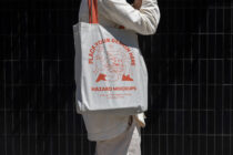 White tote bag showing red burger design on front, red handles shown close