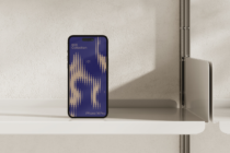 iPhone 14 Pro mockup displaying navy blue screen with gold waveform design on minimal white shelf