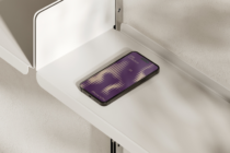 iPhone 14 Pro on white shelf cubby displaying 606 Collection waveform screen design