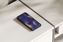 iPhone 14 Pro displaying navy 606 Collection design on white shelf