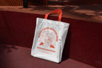 White tote with red monster illustration, place your design here tagline