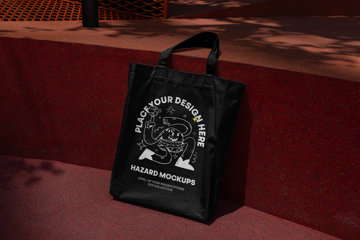 Black tote bag mockup with customizable design area featuring a cartoon graphic; ideal for showcasing branding, templates, and creative projects.