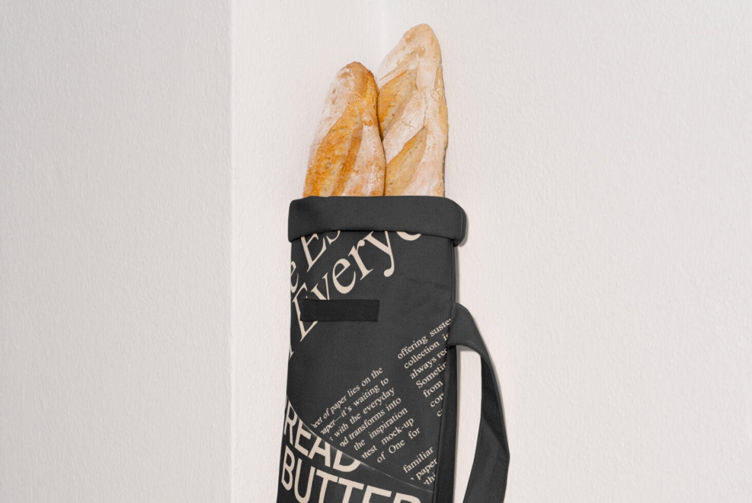 Black bag with typography design holding French baguettes mockup perfect for showcasing fonts and graphic design assets for designers and creatives.