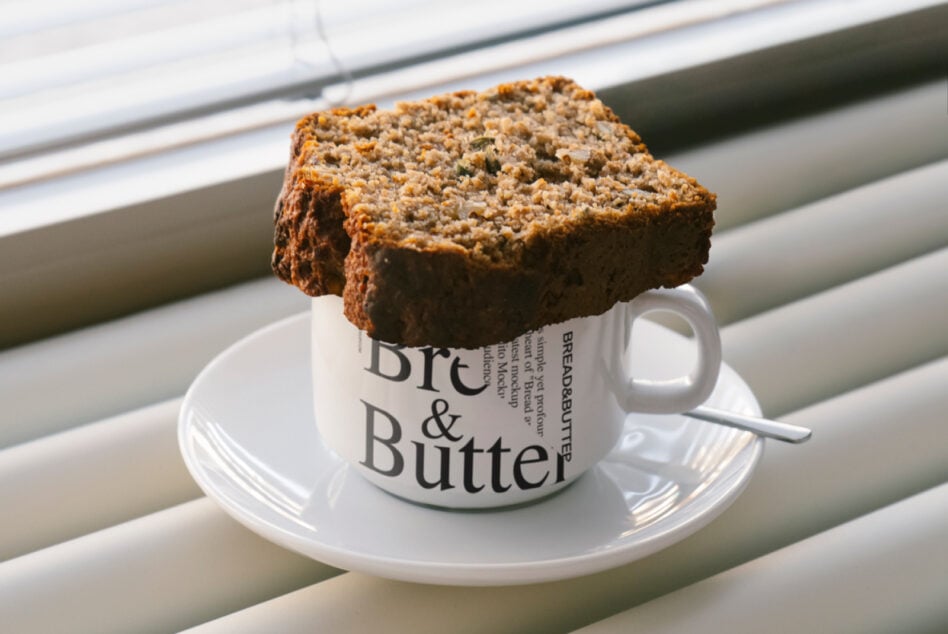 Seeded bread slice sitting on white Bread & Butter mug with saucer by window