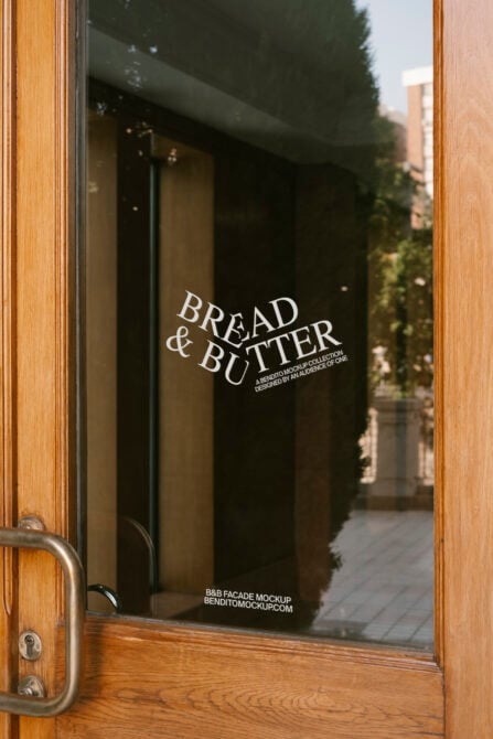 Wooden door with glass pane featuring Bread and Butter text. Ideal for storefront mockup design. Keywords: Mockup, Graphics, Template, Designers.