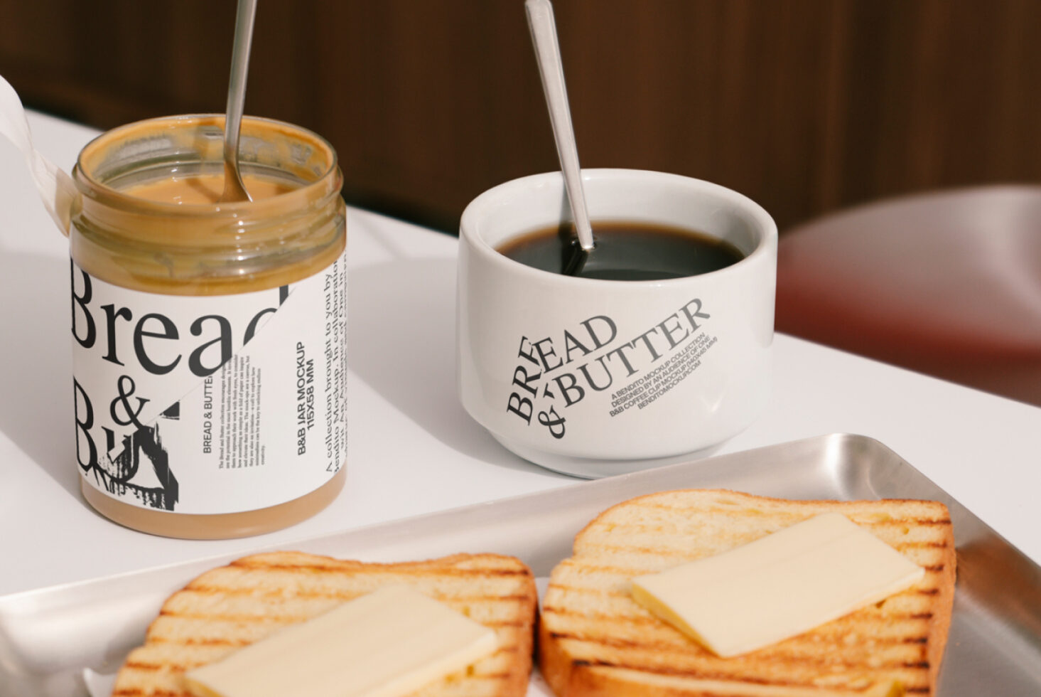 Coffee mug and jar with Bread and Butter logo, spoon in coffee, toasted bread with cheese, kitchen scene, branding mockup for designers.