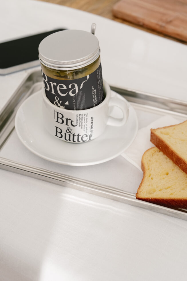 Elegant food packaging mockup featuring a jar labeled Bread and Butter on a cup with bread slices. Perfect for designers seeking realistic product presentations.